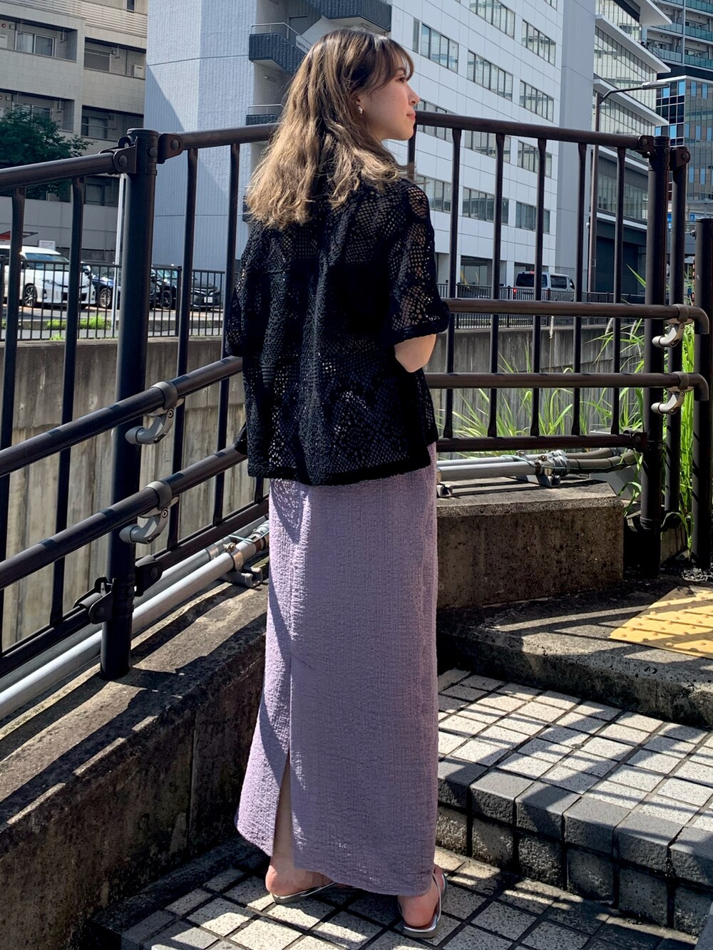 シルバー系のサンダル、パープル系のスカート、ブラック系のシャツ/ブラウスを着用したレディースの夏コーディネートの3枚目の写真