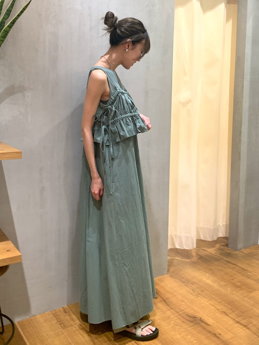 グリーン系のワンピース、ゴールド系のネックレス、シルバー系のイヤリングを着用したレディースの夏コーディネートの2枚目の写真