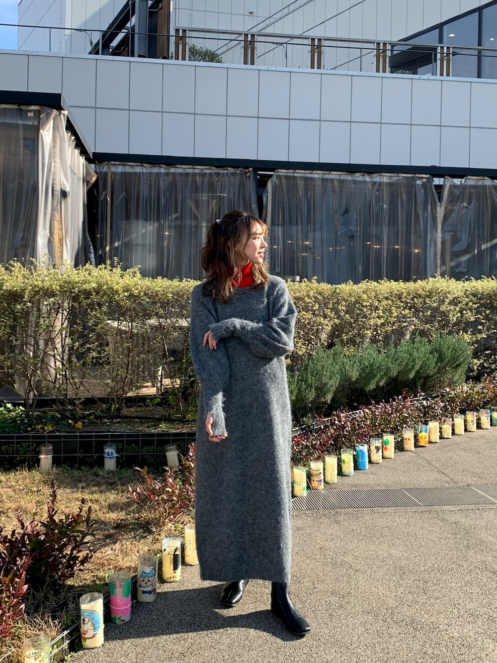 ブラック系のムートンコート、グレー系のワンピース、レッド系のニット/セーターを着用したレディースの冬コーディネートの4枚目の写真