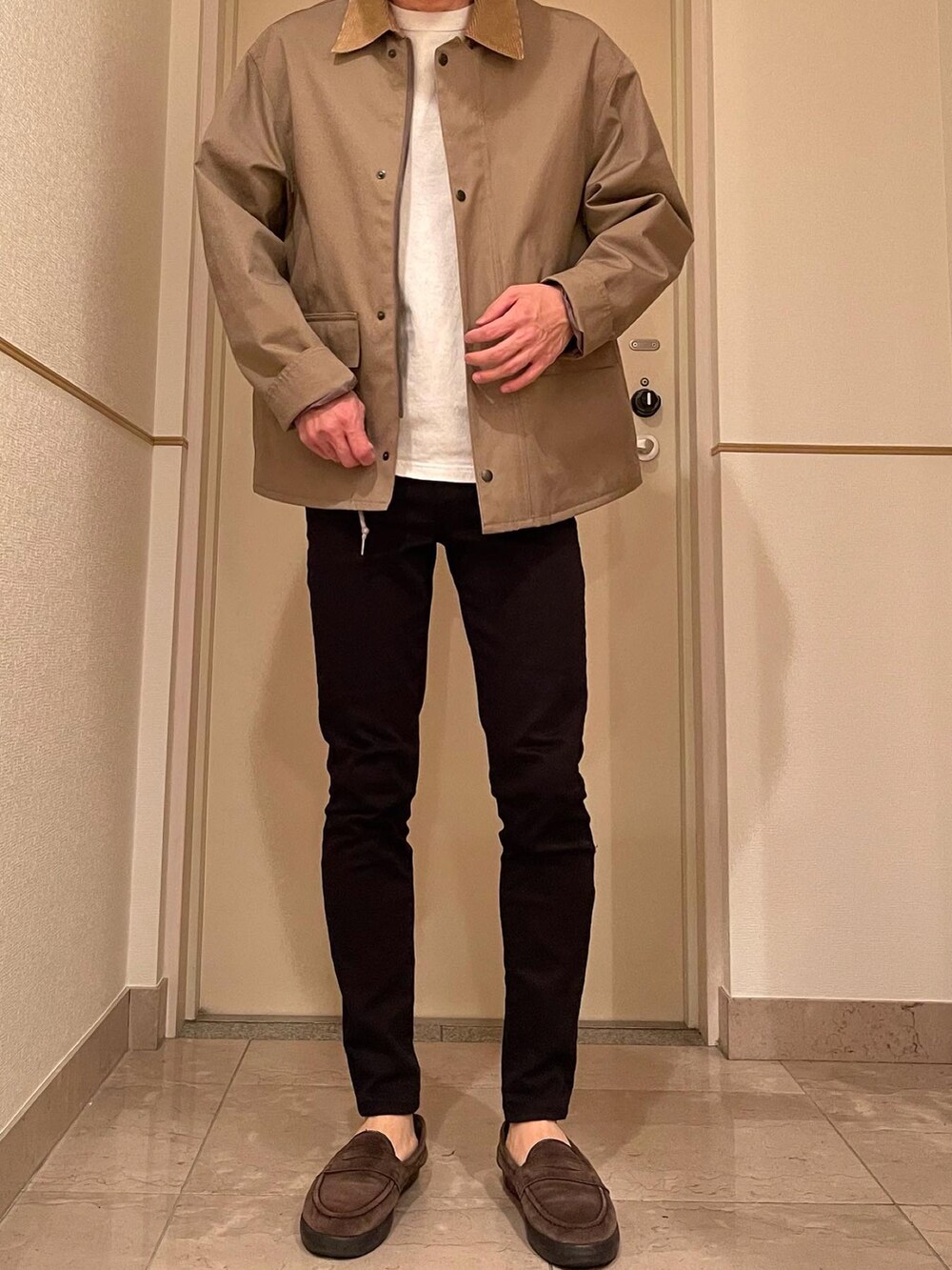 ブラック系のパンツ、ブラウン系のローファー、ベージュ系のジャケット/アウターを着用したメンズの冬コーディネートの2枚目の写真