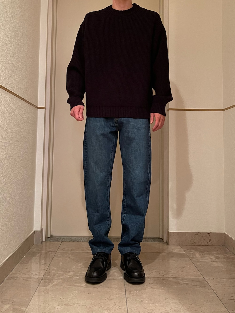 ブルー系のデニムパンツ、ブラック系のブーツ、ブラック系のニット/セーターを着用したメンズの冬コーディネートの2枚目の写真