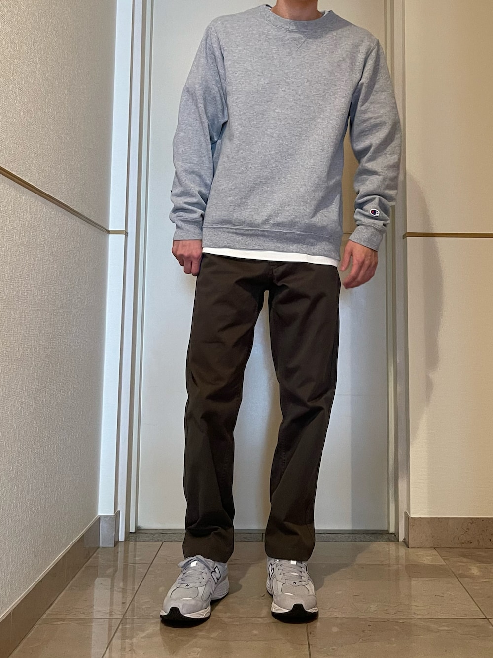 グレー系のスウェット、グリーン系のチノパンツ、グレー系のスニーカーを着用したメンズの春コーディネートの3枚目の写真