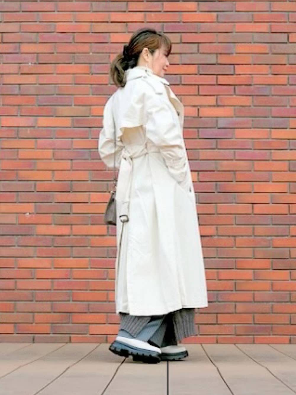 ブラウン系のショルダーバッグ、ホワイト系のトレンチコートを着用したレディースの春コーディネートの3枚目の写真