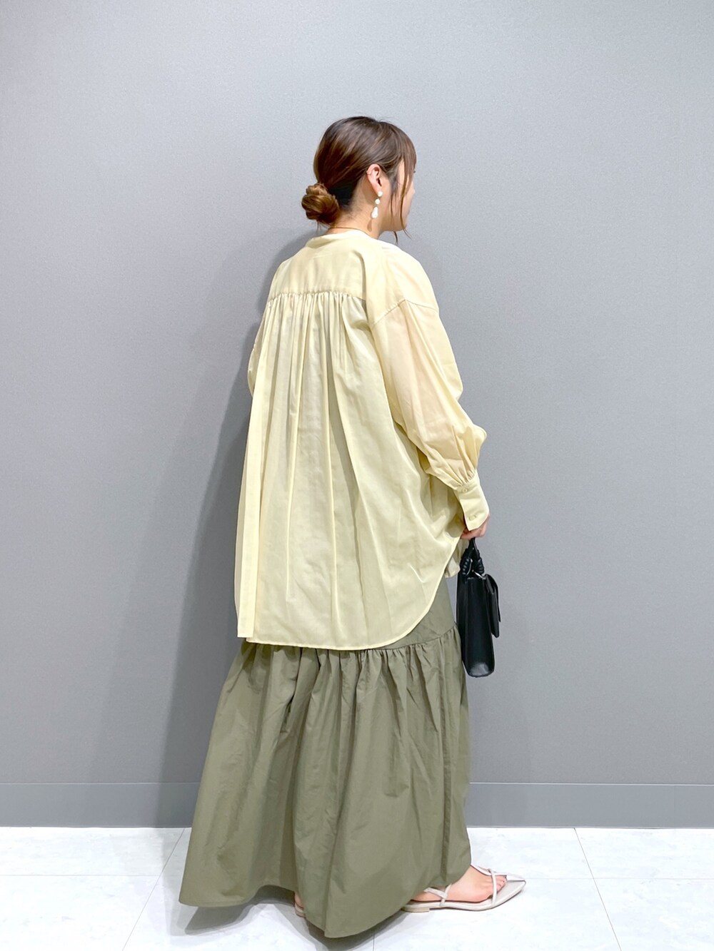 グリーン系のワンピース、イエロー系のシャツ/ブラウス、ホワイト系のタンクトップを着用したレディースの夏コーディネートの3枚目の写真