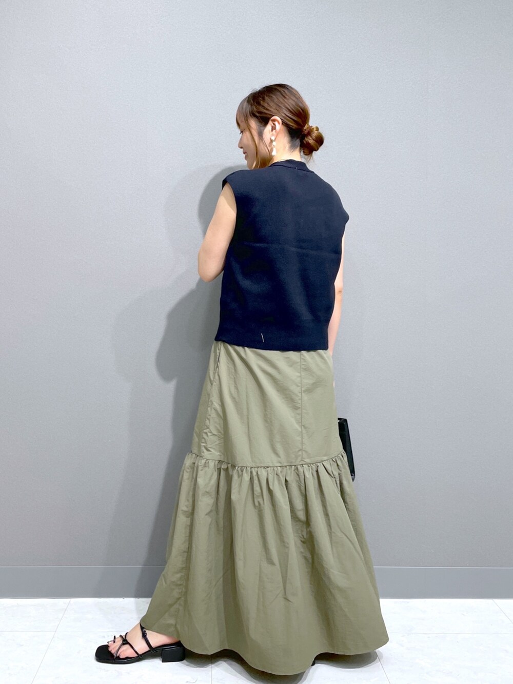 グリーン系のワンピース、ブルー系のニット/セーター、ブラック系のショルダーバッグを着用したレディースの夏コーディネートの5枚目の写真