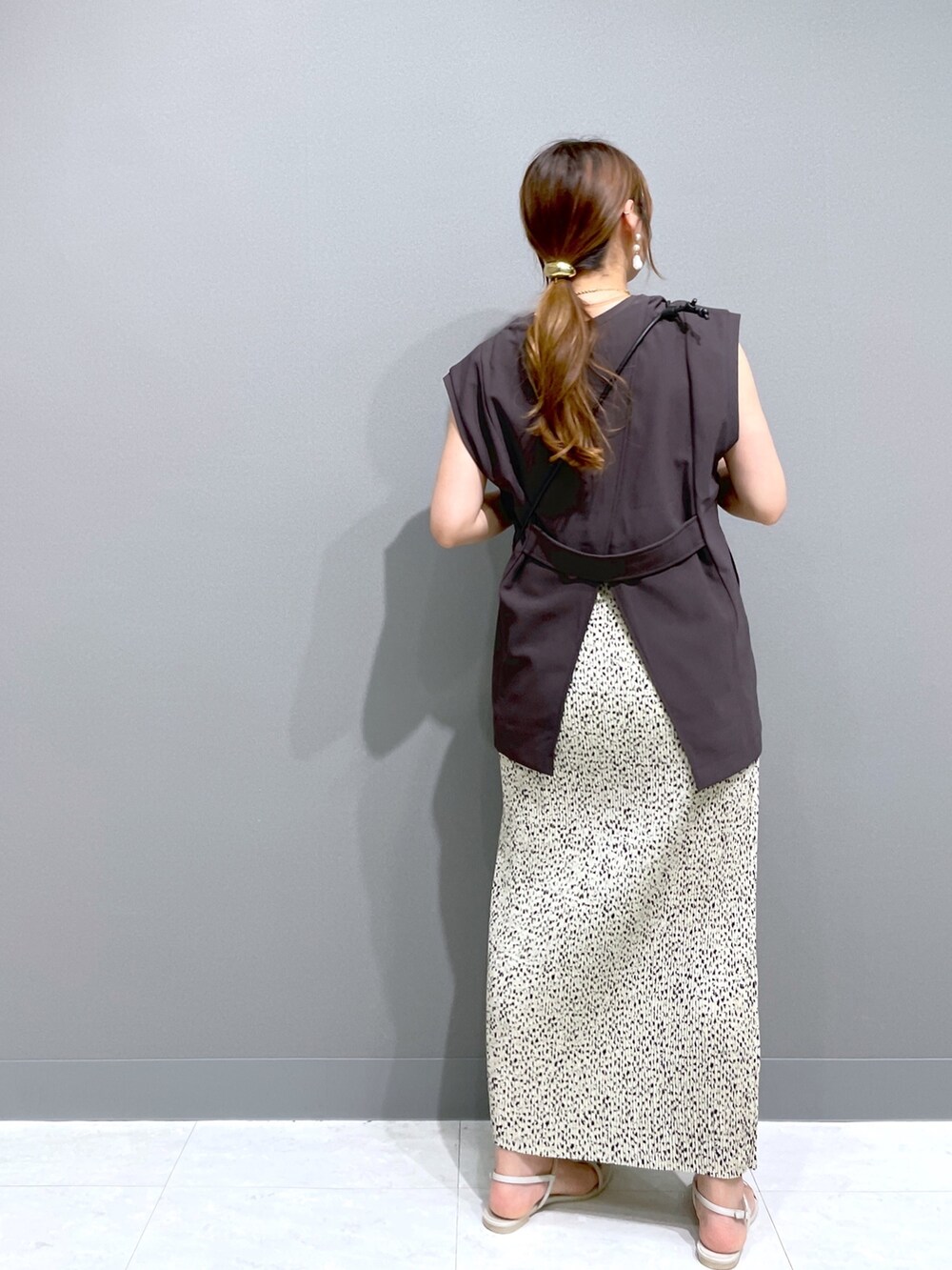 ブラック系のショルダーバッグ、ホワイト系のサンダル、ベージュ系のスカートを着用したレディースの夏コーディネートの4枚目の写真