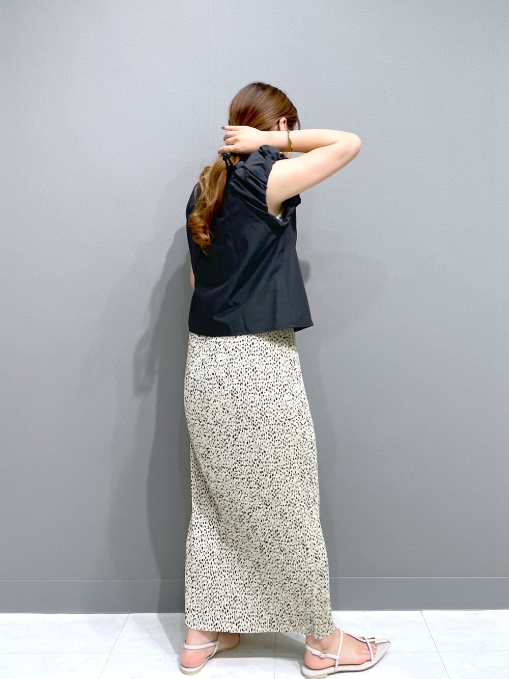 ベージュ系のスカート、ブラック系のシャツ/ブラウス、ブラック系のショルダーバッグを着用したレディースの夏コーディネートの3枚目の写真