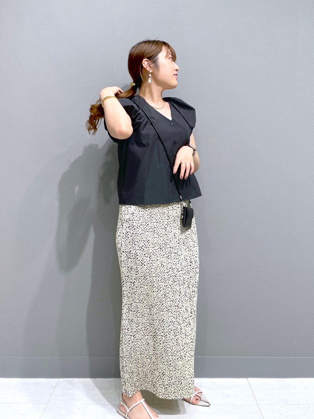 ベージュ系のスカート、ブラック系のシャツ/ブラウス、ブラック系のショルダーバッグを着用したレディースの夏コーディネートの4枚目の写真