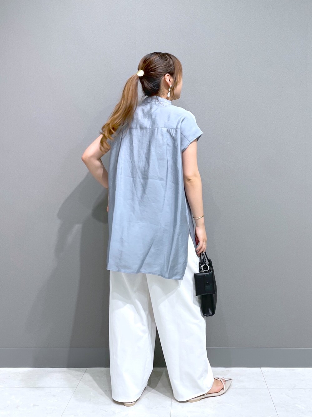 ブルー系のシャツ/ブラウス、ホワイト系のパンツ、ホワイト系のサンダルを着用したレディースの秋コーディネートの4枚目の写真