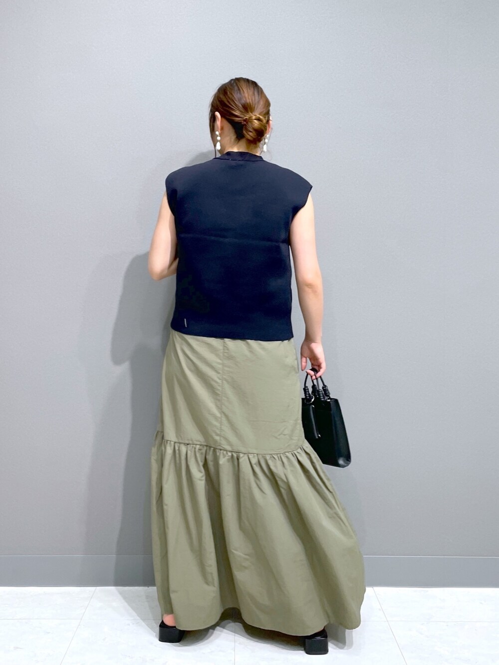 グリーン系のワンピース、ブルー系のニット/セーター、ブラック系のショルダーバッグを着用したレディースの夏コーディネートの4枚目の写真