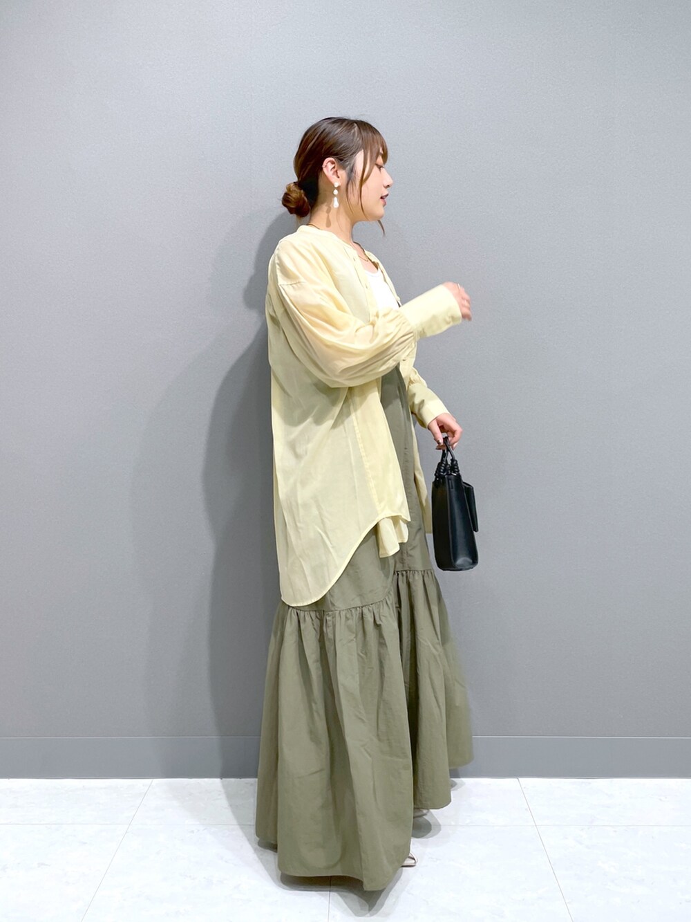 グリーン系のワンピース、イエロー系のシャツ/ブラウス、ホワイト系のタンクトップを着用したレディースの夏コーディネートの4枚目の写真