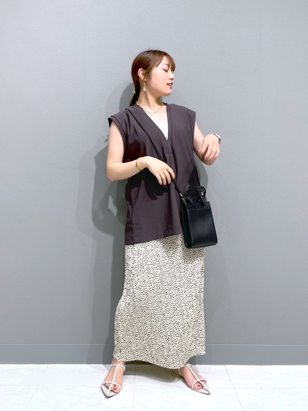 ブラック系のショルダーバッグ、ホワイト系のサンダル、ベージュ系のスカートを着用したレディースの夏コーディネートの3枚目の写真