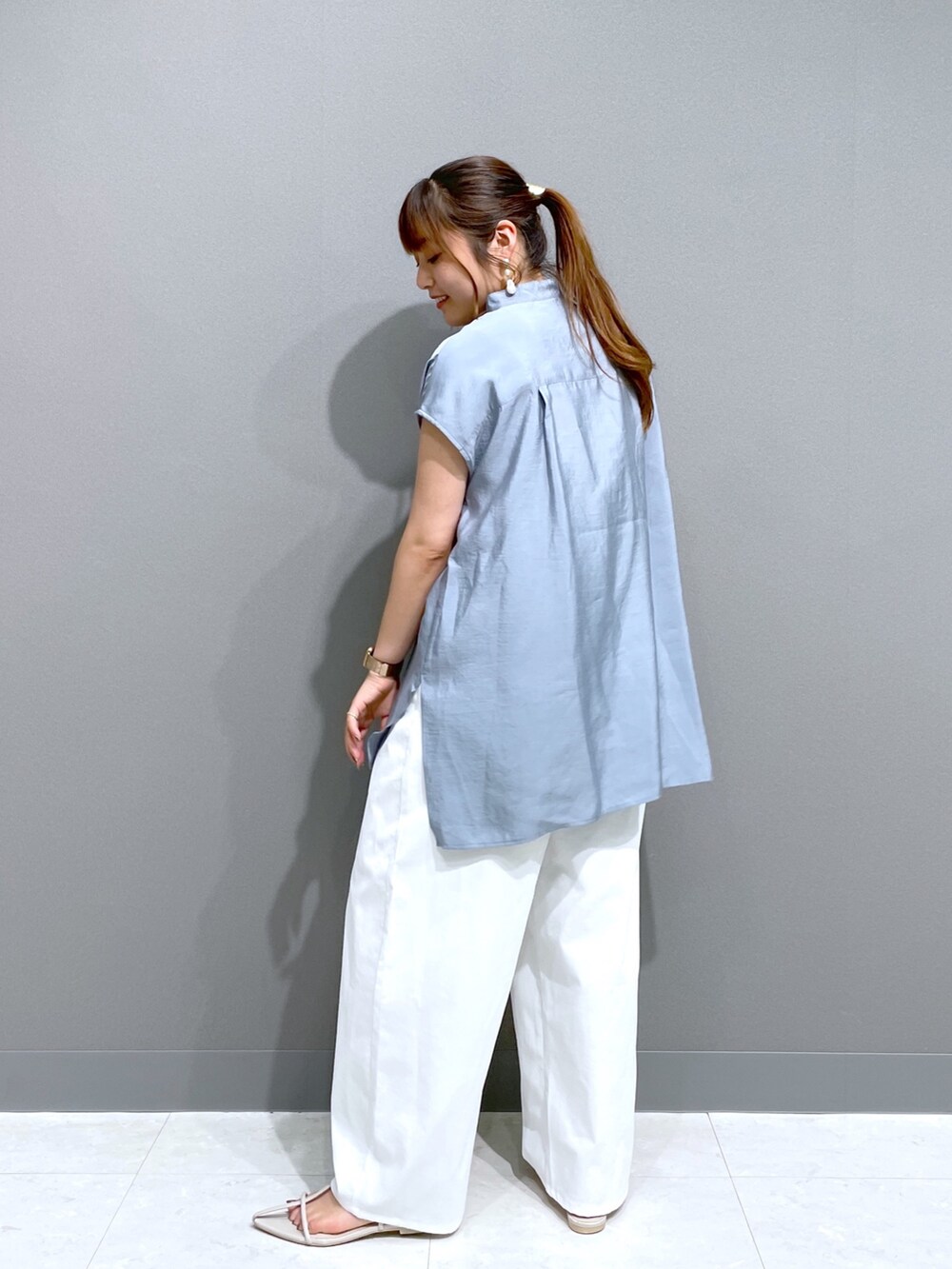 ブルー系のシャツ/ブラウス、ホワイト系のパンツ、ホワイト系のサンダルを着用したレディースの秋コーディネートの3枚目の写真