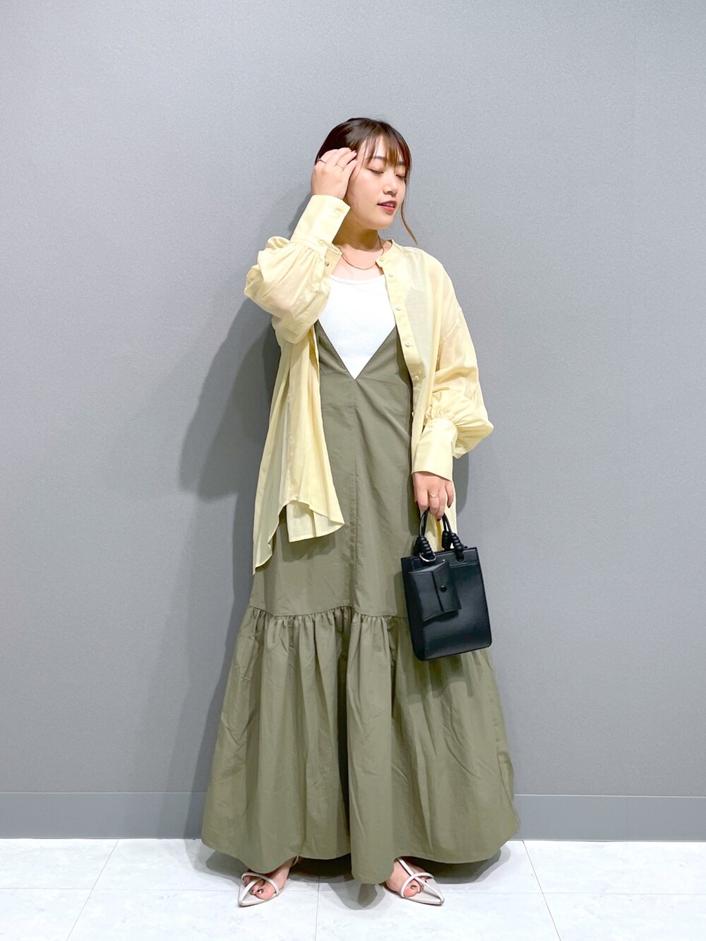 グリーン系のワンピース、イエロー系のシャツ/ブラウス、ホワイト系のタンクトップを着用したレディースの夏コーディネートの5枚目の写真