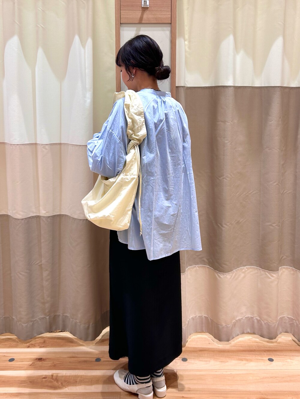 ブラック系のスカート、ブルー系のTシャツ/カットソー、ホワイト系のドレスシューズを着用したレディースの冬コーディネートの2枚目の写真