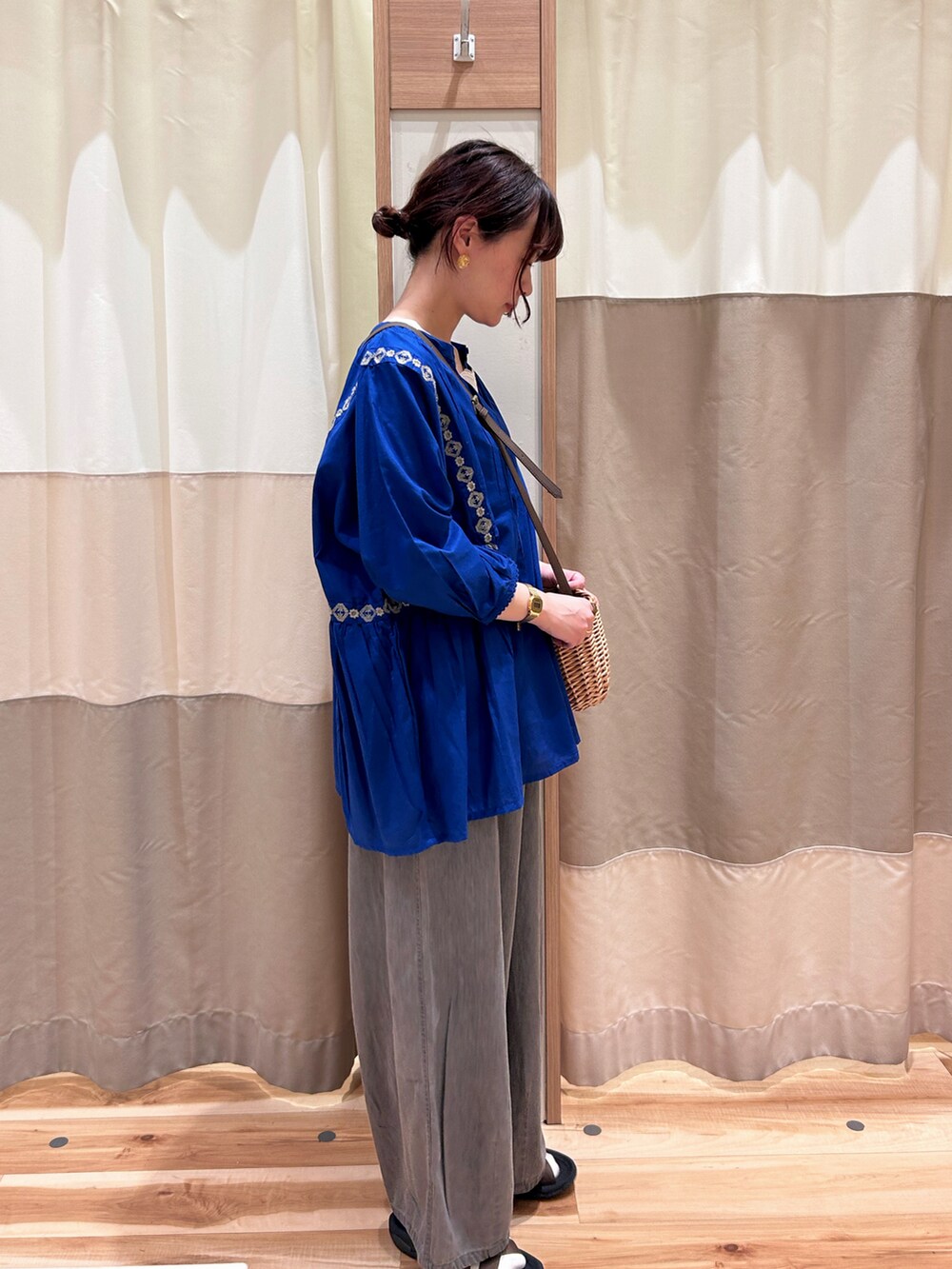 ブルー系のシャツ/ブラウス、ホワイト系のタンクトップ、ブラウン系のハンドバッグを着用したレディースの春コーディネートの2枚目の写真