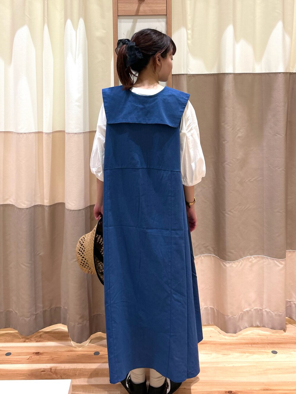 ブラック系のサンダル、ブルー系のワンピース、ホワイト系のTシャツ/カットソーを着用したレディースの春コーディネートの2枚目の写真