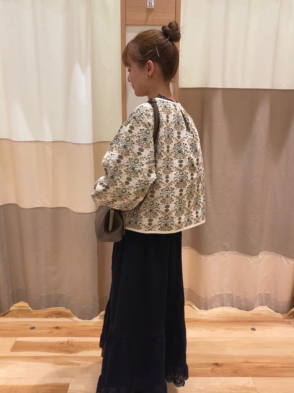 ブラック系のスカート、ブラウン系のハンドバッグ、ブラック系のその他シューズを着用したレディースの秋コーディネートの2枚目の写真