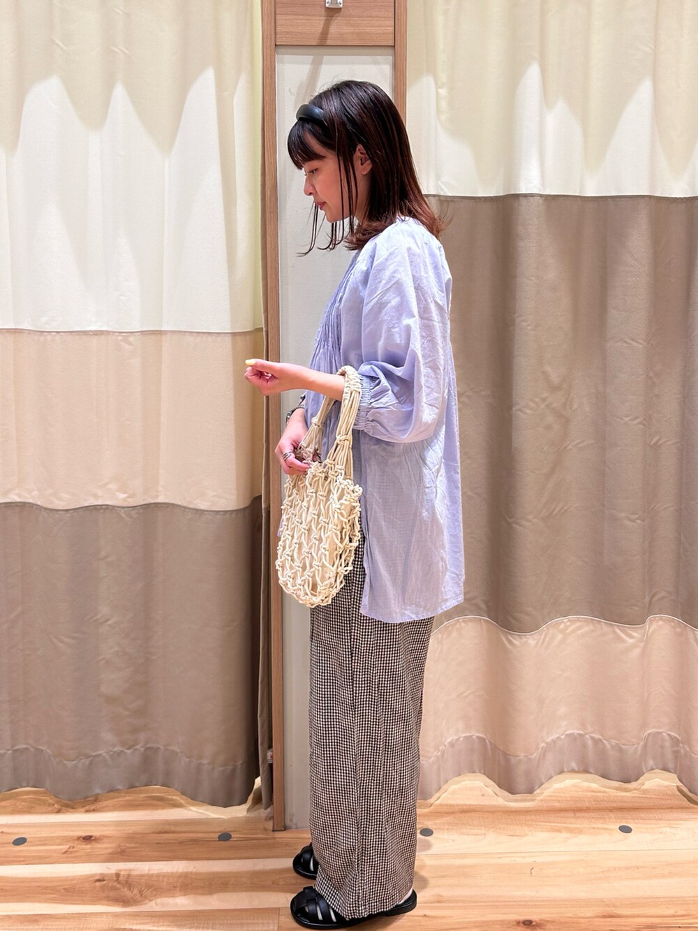 ホワイト系のハンドバッグ、パープル系のシャツ/ブラウス、ブラック系のサンダルを着用したレディースの春コーディネートの2枚目の写真