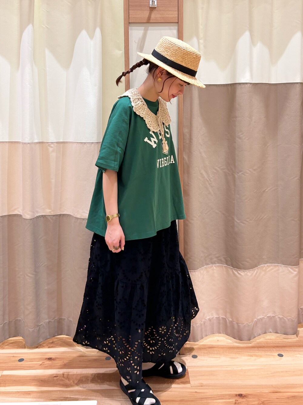 グリーン系のTシャツ/カットソー、ブラック系のサンダル、ブラック系のスカートを着用したレディースの春コーディネートの2枚目の写真