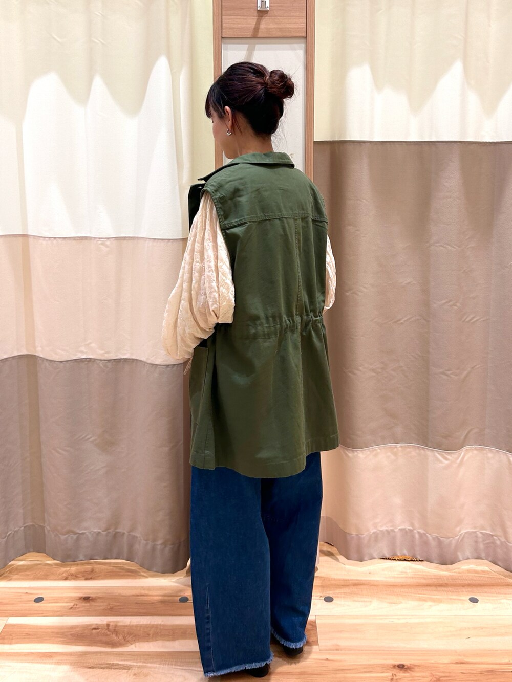 ホワイト系のシャツ/ブラウス、グリーン系のベスト、ブルー系のデニムパンツを着用したレディースの夏コーディネートの3枚目の写真