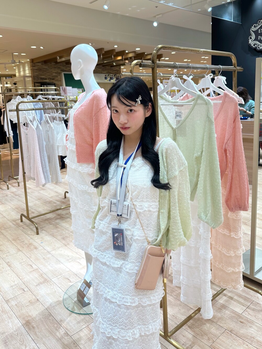 グリーン系のカーディガン/ボレロ、ホワイト系のワンピース、ピンク系のショルダーバッグを着用したレディースの春コーディネートの3枚目の写真