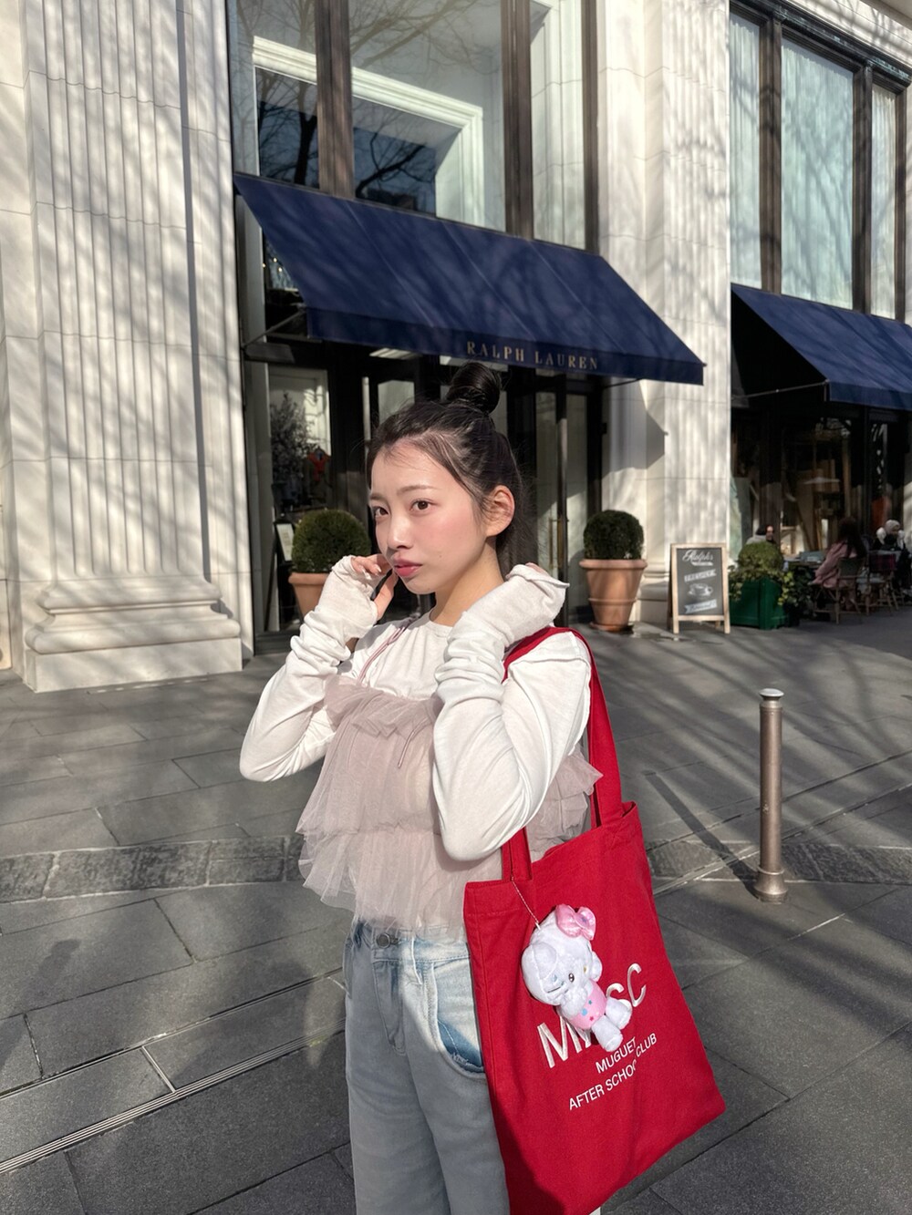 レッド系のトートバッグ、パープル系のアンサンブル、グレー系のスニーカーを着用したレディースの春コーディネートの4枚目の写真