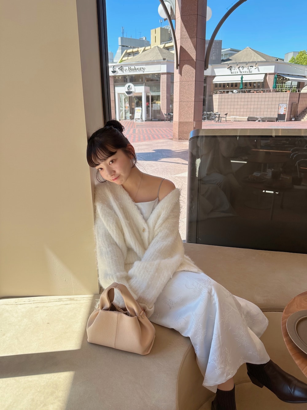 ホワイト系のカーディガン/ボレロ、ブルー系のワンピースを着用したレディースの秋コーディネートの3枚目の写真