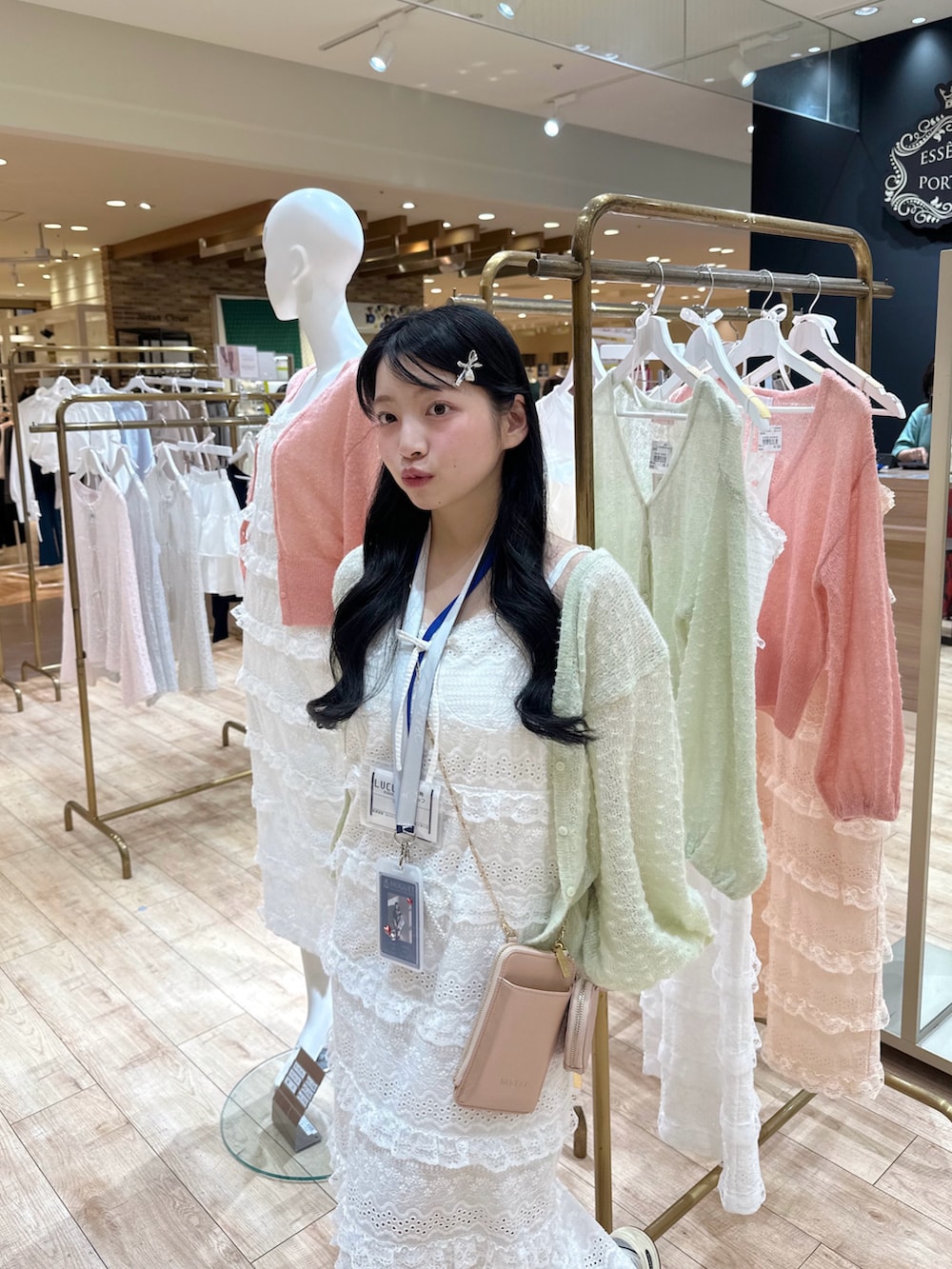 グリーン系のカーディガン/ボレロ、ホワイト系のワンピース、ピンク系のショルダーバッグを着用したレディースの春コーディネートの4枚目の写真