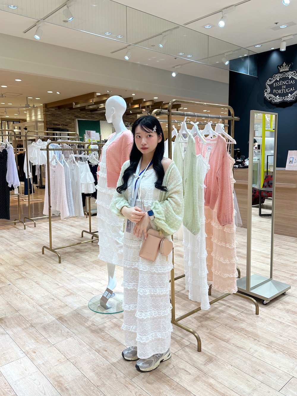 グリーン系のカーディガン/ボレロ、ホワイト系のワンピース、ピンク系のショルダーバッグを着用したレディースの春コーディネートの2枚目の写真