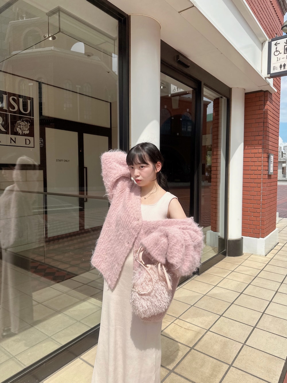 ピンク系のカーディガン/ボレロ、ホワイト系のワンピース、ピンク系のバッグを着用したレディースの秋コーディネートの2枚目の写真