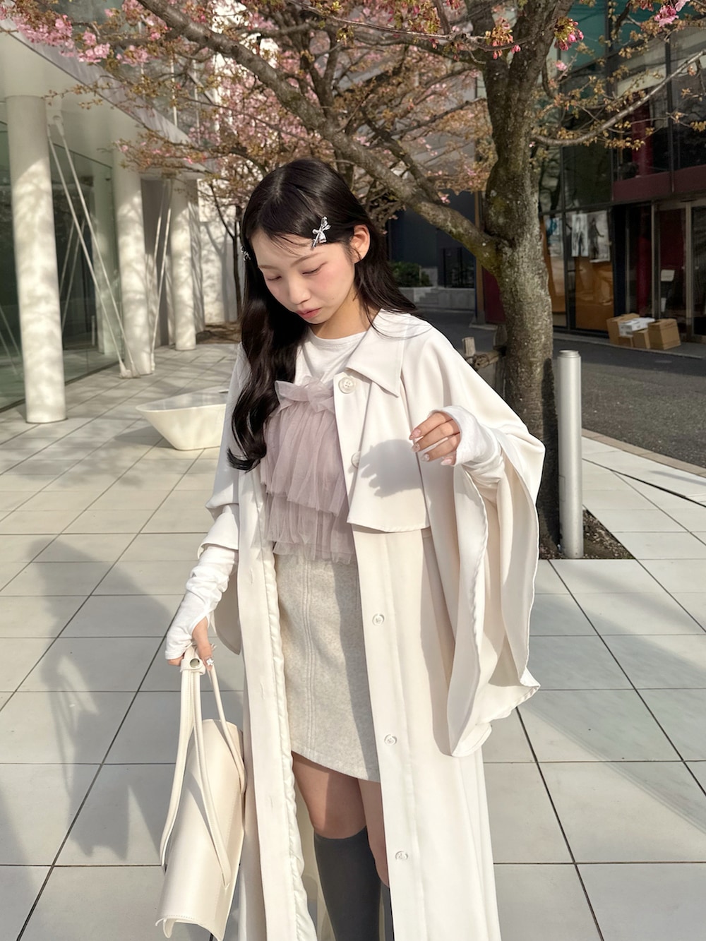 ホワイト系のトレンチコート、パープル系のトップス、ピンク系のその他を着用したレディースの春コーディネートの2枚目の写真