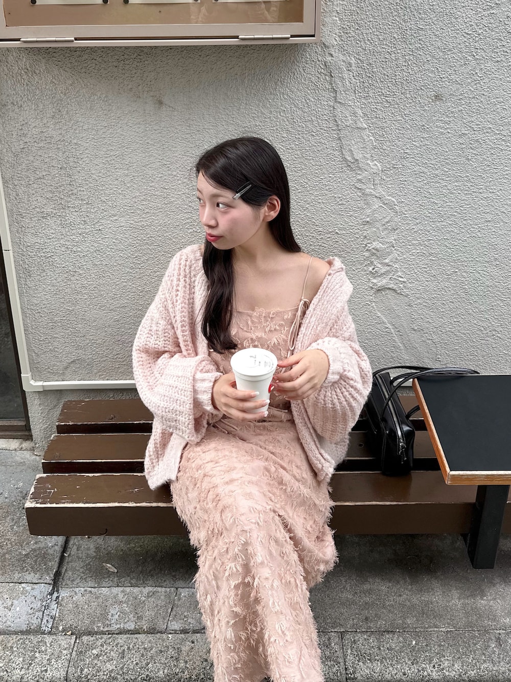 ピンク系のワンピース、ピンク系のカーディガン/ボレロ、ブラック系のショルダーバッグを着用したレディースの秋コーディネートの4枚目の写真