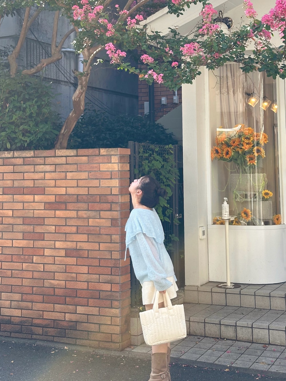 ブルー系のニット/セーター、ホワイト系のパンツ、ホワイト系のバッグを着用したレディースの秋コーディネートの3枚目の写真