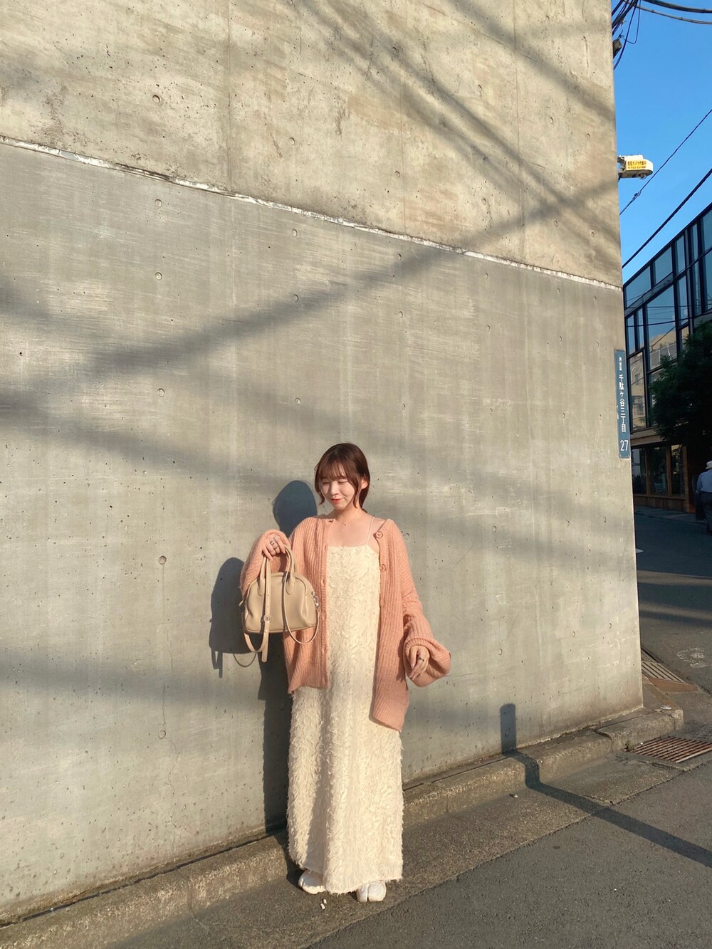 ホワイト系のワンピース、ピンク系のカーディガン/ボレロを着用したレディースの秋コーディネートの2枚目の写真