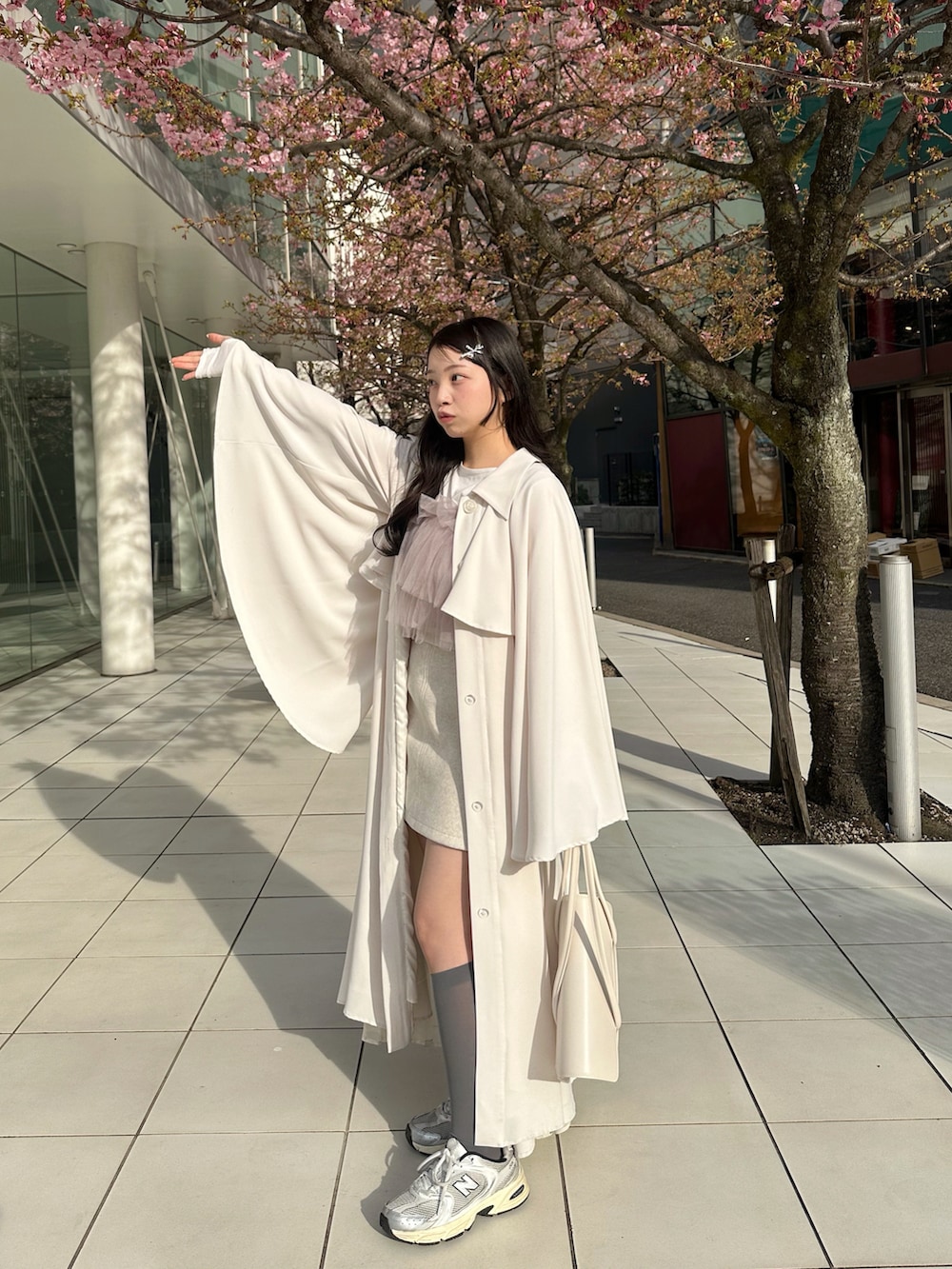 ホワイト系のトレンチコート、パープル系のトップス、ピンク系のその他を着用したレディースの春コーディネートの3枚目の写真