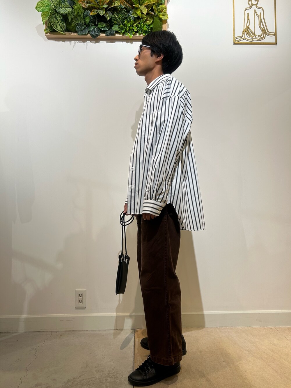 ブラック系のTシャツ/カットソー、ホワイト系のシャツ/ブラウス、ブラック系のショルダーバッグを着用したメンズの秋コーディネートの2枚目の写真