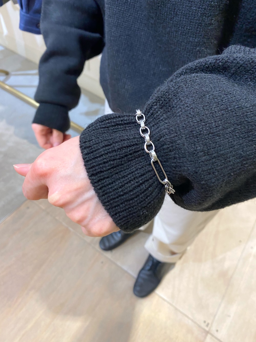 ブラック系のニット/セーター、ブラック系のバックパック/リュック、シルバー系のネックレスを着用したレディースの秋コーディネートの5枚目の写真