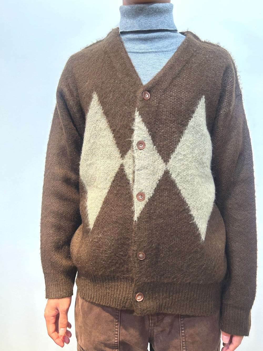 ブラウン系のカーディガン/ボレロ、グレー系のニット/セーター、ブラウン系のパンツを着用したレディースの冬コーディネートの4枚目の写真