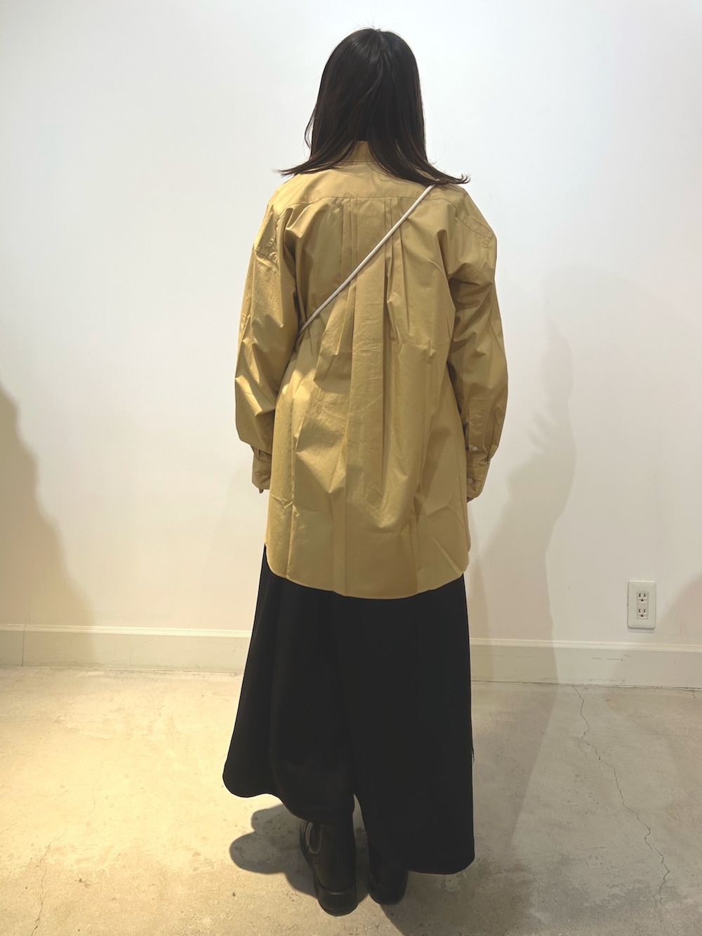 ベージュ系のショルダーバッグ、ブラック系のスカート、ベージュ系のシャツ/ブラウスを着用したレディースの冬コーディネートの3枚目の写真