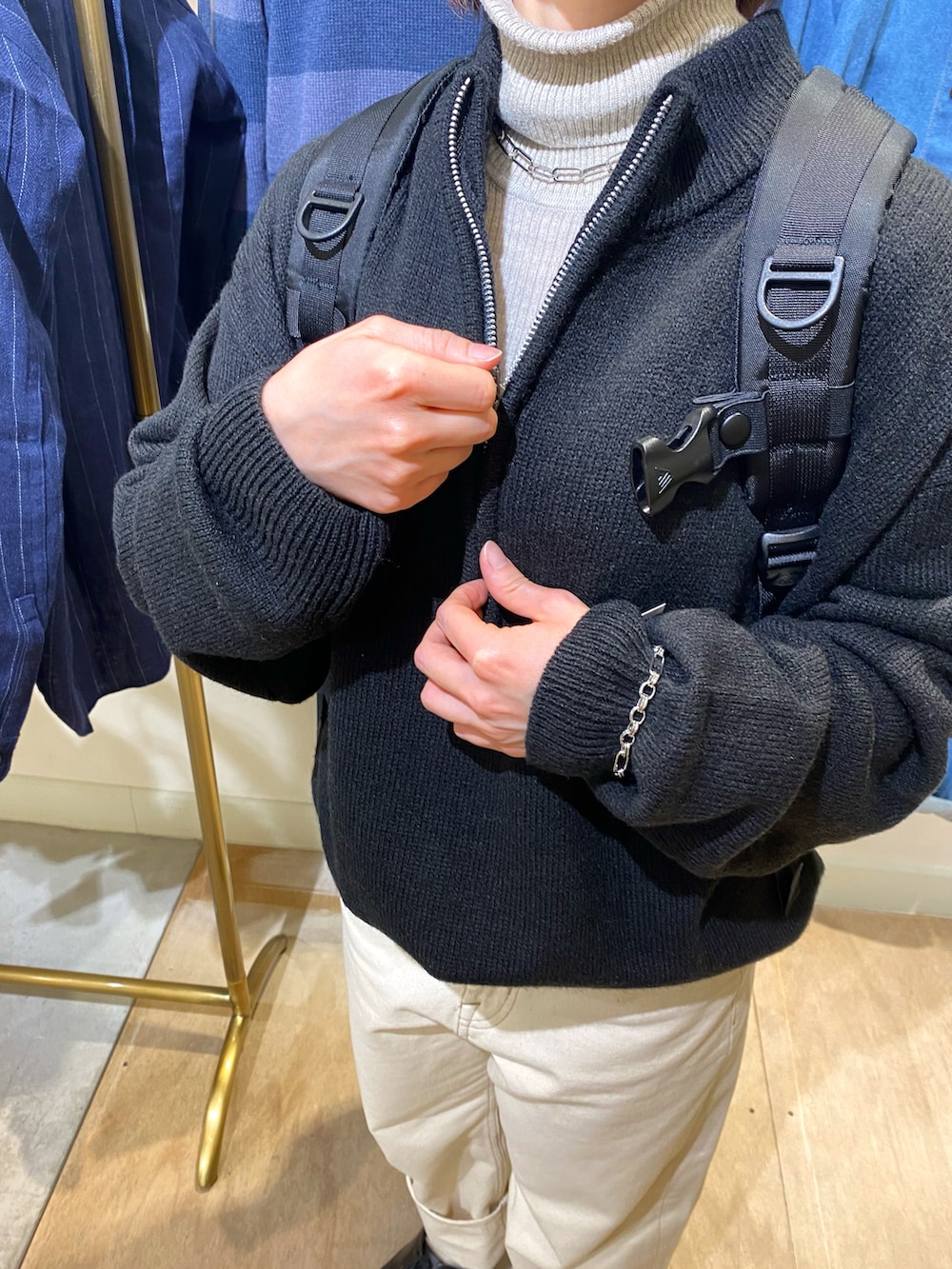 ブラック系のニット/セーター、ブラック系のバックパック/リュック、シルバー系のネックレスを着用したレディースの秋コーディネートの4枚目の写真