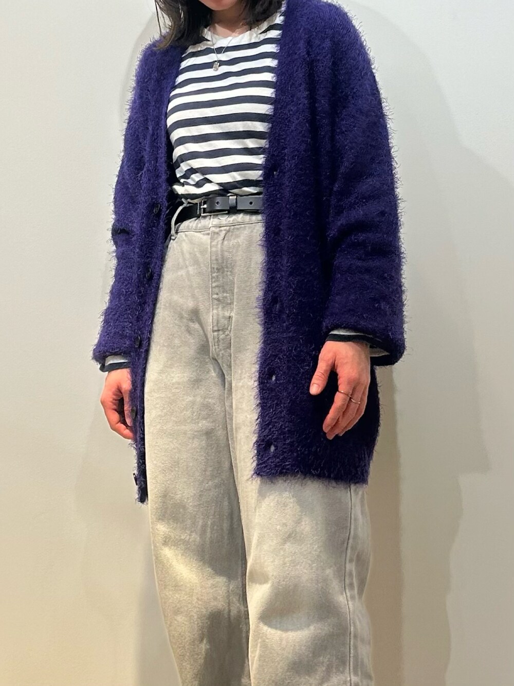 ブラック系のスニーカー、グレー系のデニムパンツ、パープル系のカーディガン/ボレロを着用したレディースの秋コーディネートの4枚目の写真