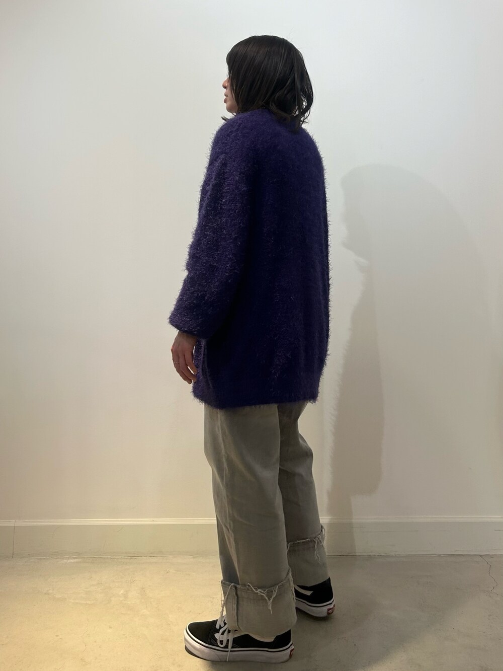 ブラック系のスニーカー、グレー系のデニムパンツ、パープル系のカーディガン/ボレロを着用したレディースの秋コーディネートの3枚目の写真