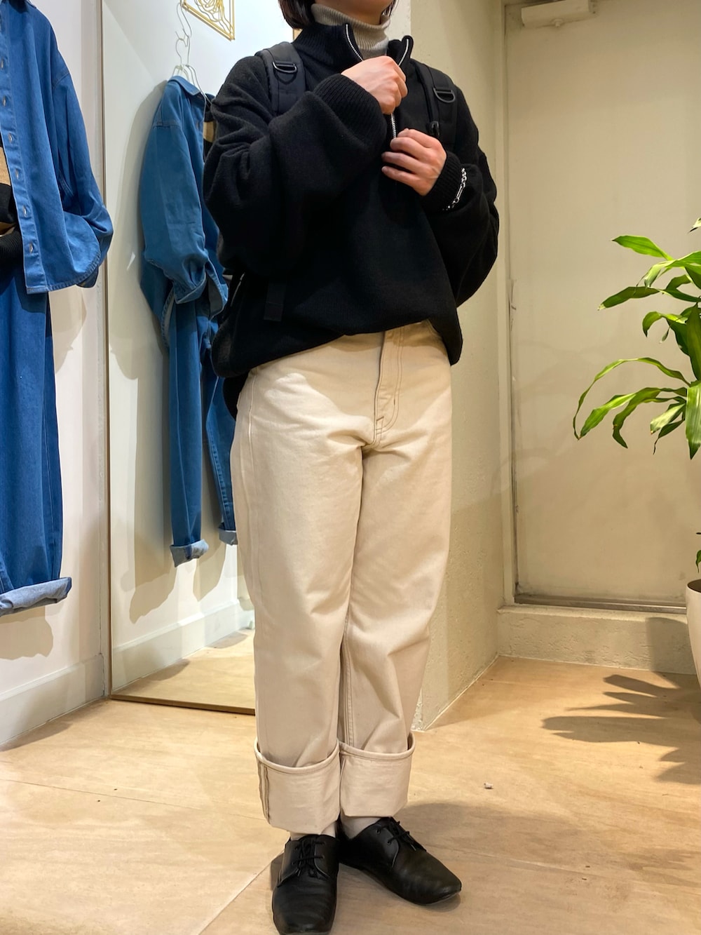 ブラック系のニット/セーター、ブラック系のバックパック/リュック、シルバー系のネックレスを着用したレディースの秋コーディネートの3枚目の写真