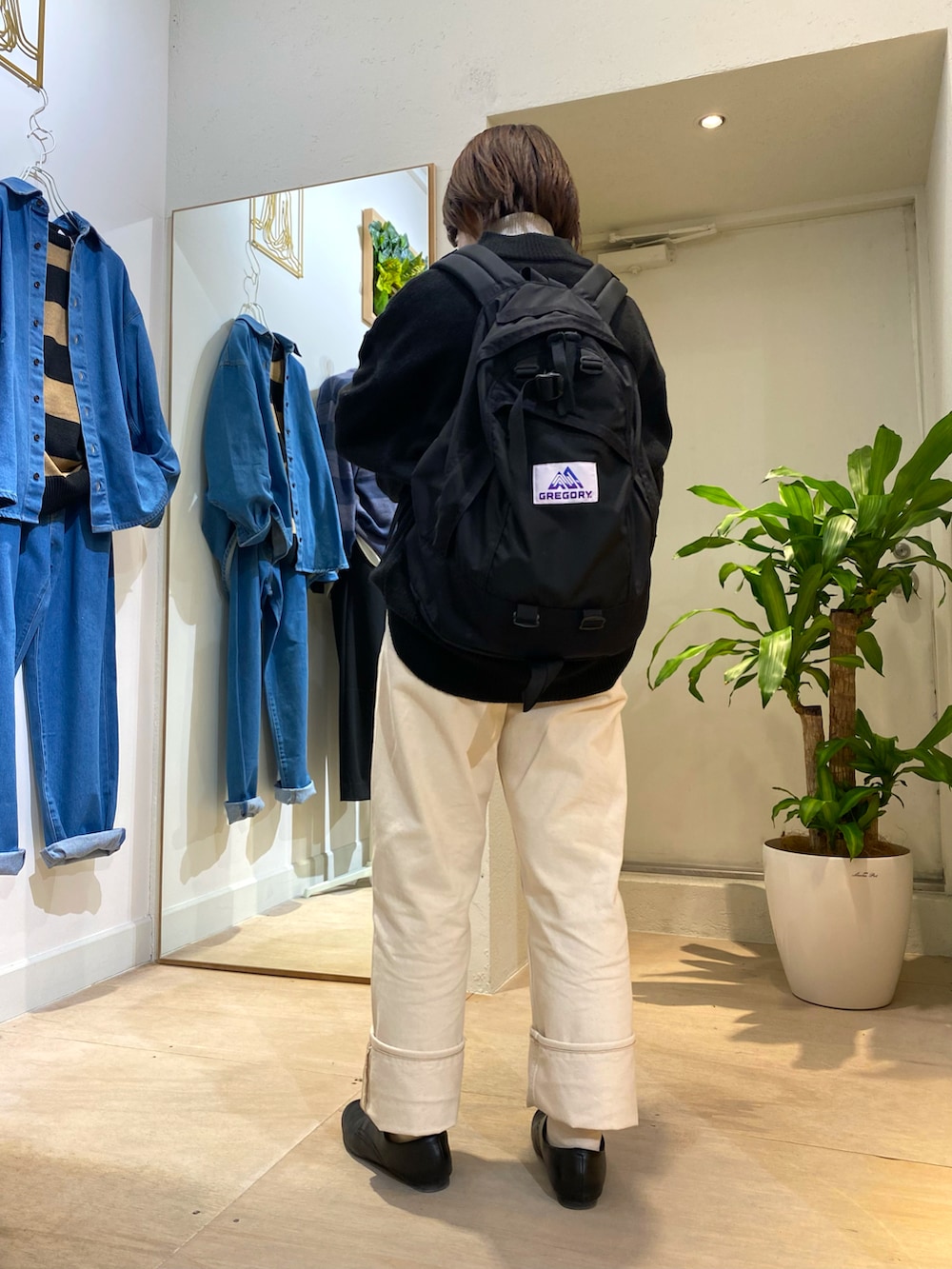 ブラック系のニット/セーター、ブラック系のバックパック/リュック、シルバー系のネックレスを着用したレディースの秋コーディネートの2枚目の写真