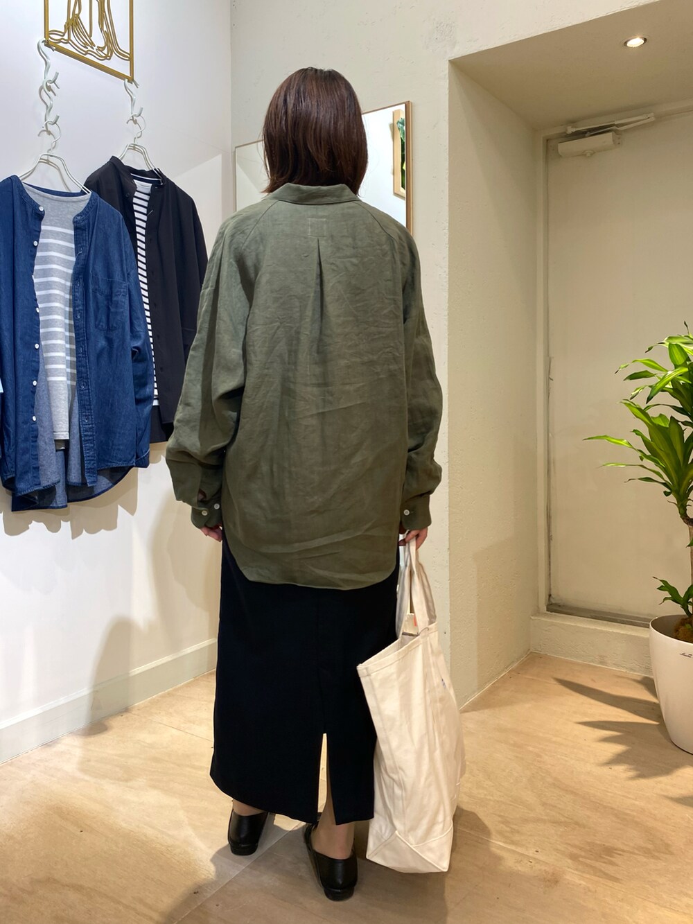 グリーン系のシャツ/ブラウス、ホワイト系のトートバッグを着用したレディースの秋コーディネートの3枚目の写真