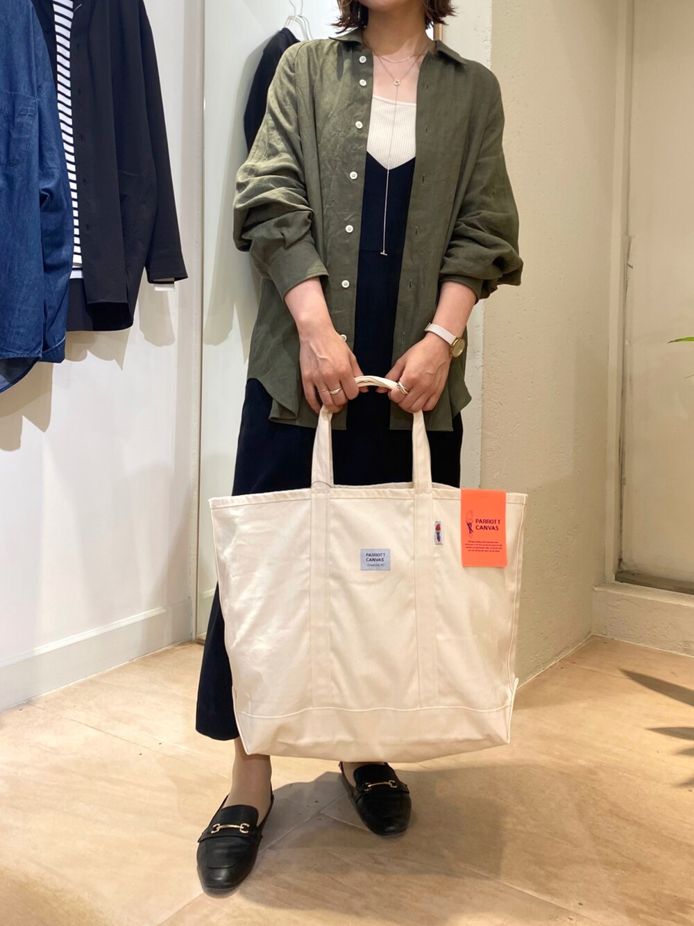 グリーン系のシャツ/ブラウス、ホワイト系のトートバッグを着用したレディースの秋コーディネートの4枚目の写真