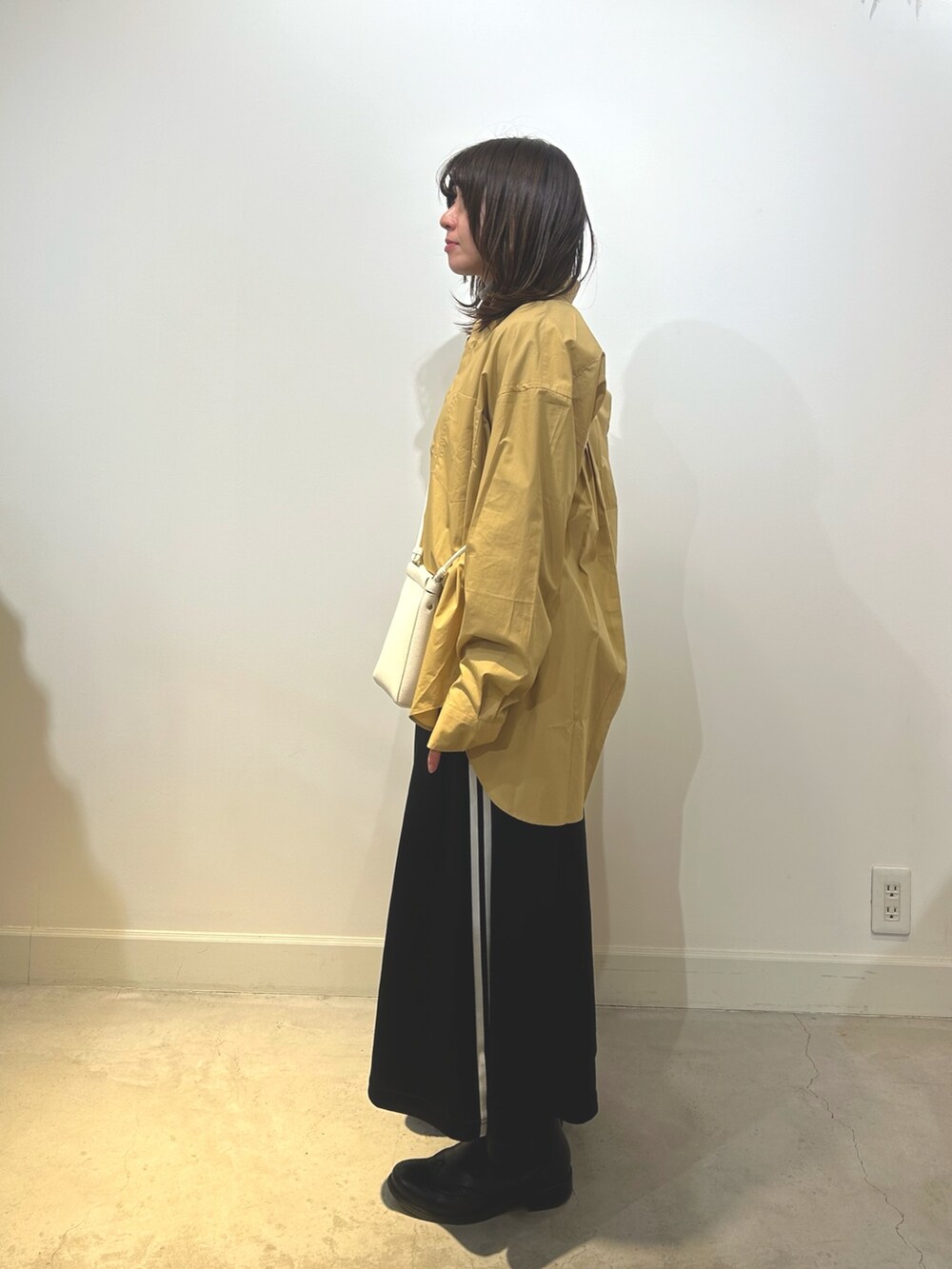 ベージュ系のショルダーバッグ、ブラック系のスカート、ベージュ系のシャツ/ブラウスを着用したレディースの冬コーディネートの2枚目の写真