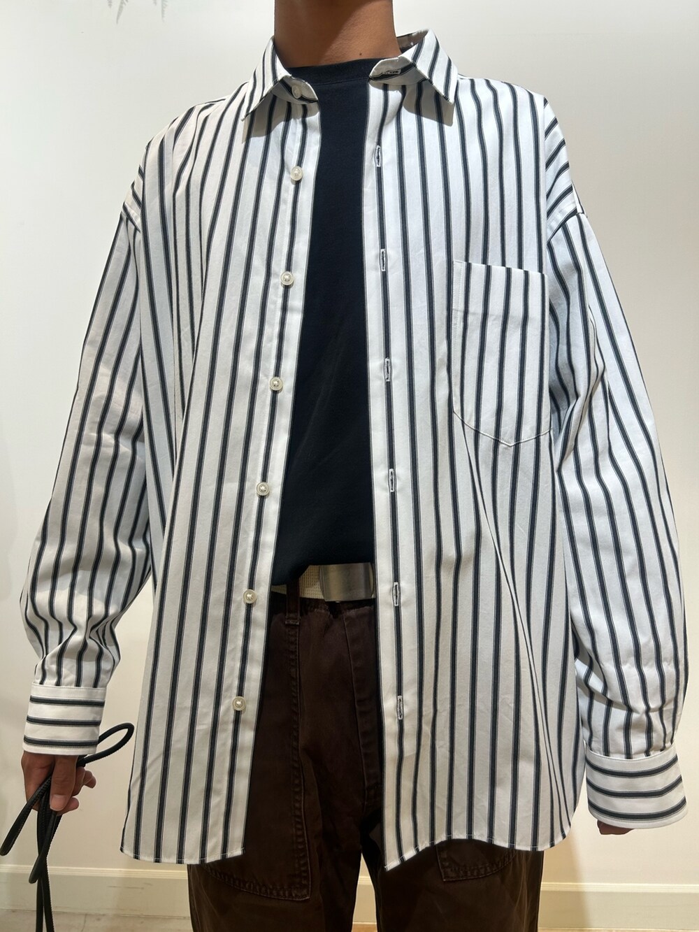 ブラック系のTシャツ/カットソー、ホワイト系のシャツ/ブラウス、ブラック系のショルダーバッグを着用したメンズの秋コーディネートの4枚目の写真