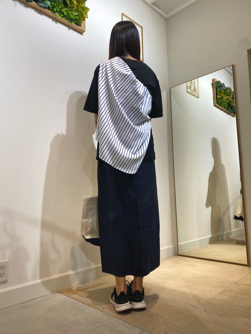 ブラック系のTシャツ/カットソー、ブルー系のトートバッグ、ブルー系のスカートを着用したレディースの秋コーディネートの3枚目の写真